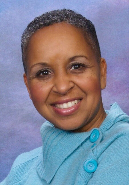 A woman with short hair is smiling for the camera.